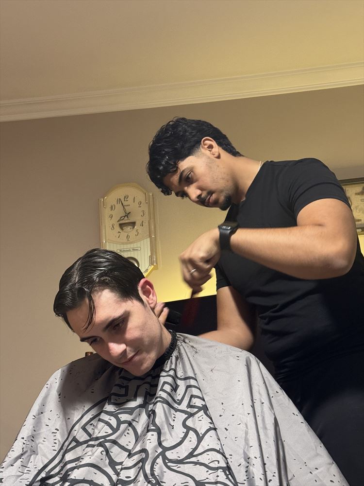 Abde cutting a client's hair at the client's home